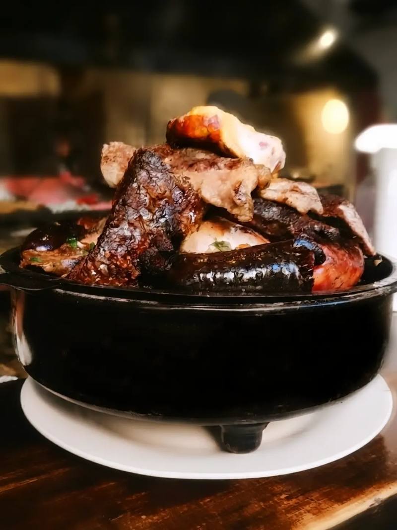 Brasero de hierro con asado, chorizo y morcilla recién salidos de la parrilla